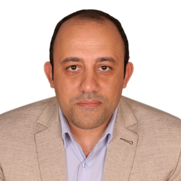 Ahmed Esmael, pictured against a white background wearing a beige sport coat with a light colored collared shirt underneath.