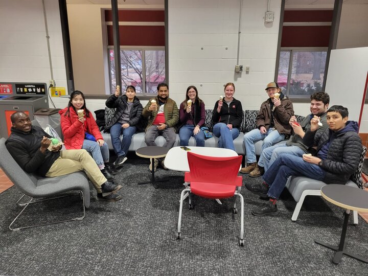 Students sit in a half circle around a table, each holding ice cream